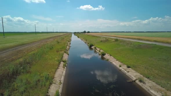 Irrigation Canal Along Agricultural Field, Flying Shot Over Water, Aerial View