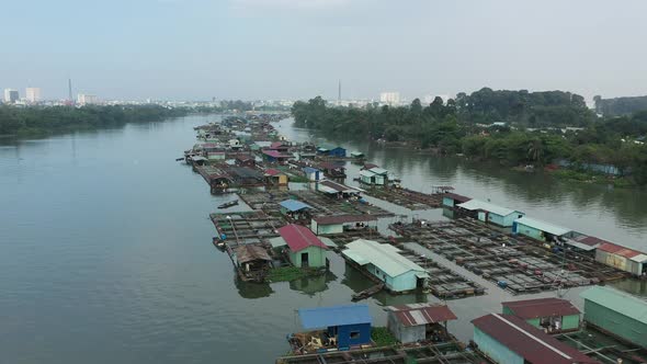 slow tracking drone shot over floating fish farming community in Bien Hoa on the Dong Nai river, Vie alt