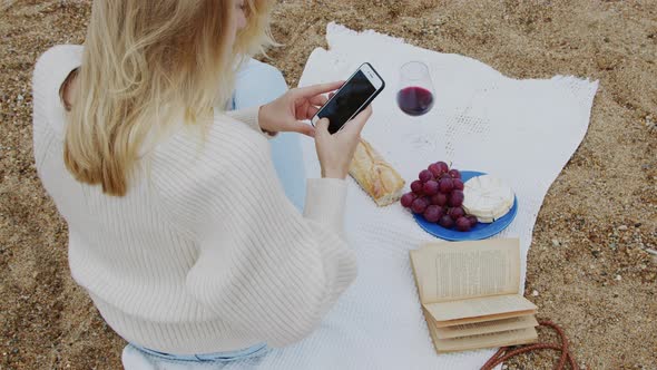 Young Woman Takes Picture of Picnic
