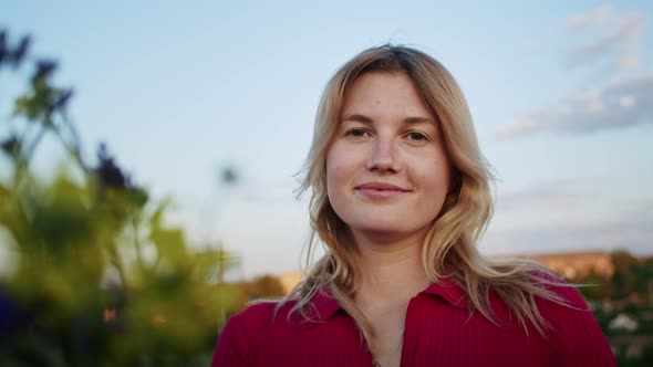 a Young Woman Happily Picks Flowers on the Mountain Hills During Sunset for Rest After a Hike alt
