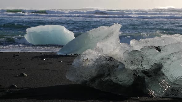 Iceland Jokulsarlon Black Sand Diamond Beach With Iceberg Ice Chunks On Ocean Shoreline