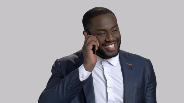 Smiling Businessman Using Telephone on Grey Background. alt