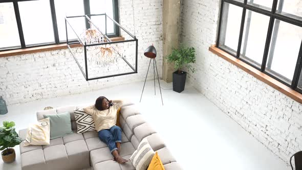 High Angle View of the Charming Modern Woman Resting Sitting on Comfortable Couch alt