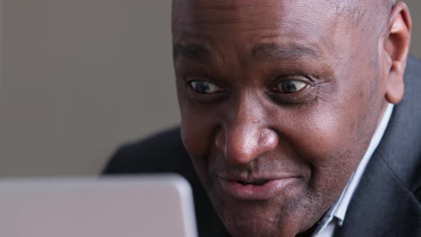 Mature African Business Man Using Laptop for Video Call Speaks Remotely Emotionally alt
