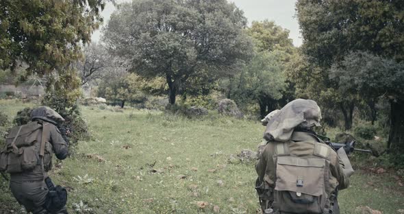 Squad of fully armed commando soldiers during combat in a forest scenery alt