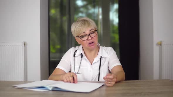 A Pleasant Women Doc with Short Haircut in Glasses is Giving Recommendations