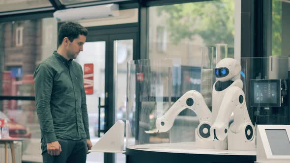Coffeeserving Robot is Moving Its Arms While Waiting for Clients alt