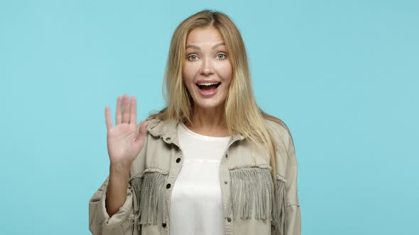 Slow Motion of Adult Blond Woman in 30s Waving Hand and Saying Hello Smiling Friendly Greeting you