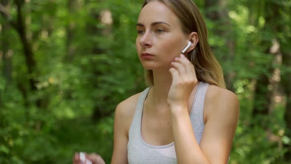 Young Girl Is Put on Earphones and Runing in Park in Summer, Healthy Lifestyle. alt
