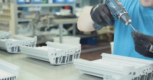 Worker testing LED lamp in an advanced electronics manufacturing facility alt