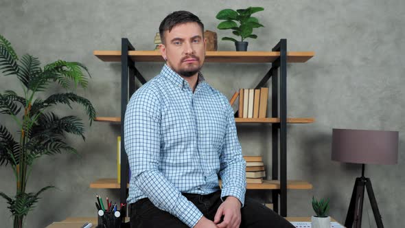 Man financial analyst broker sitting at desk in office turns head looking camera alt