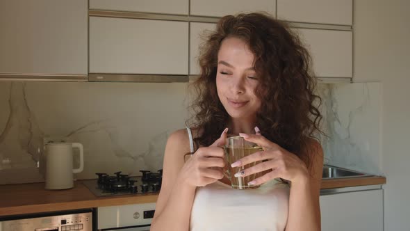 The Woman is Looking at the Camera and Smiling alt