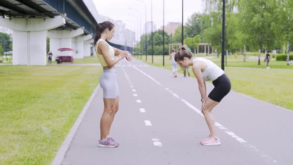 Women with Ponytail Do Sports Exercises in Green Garden