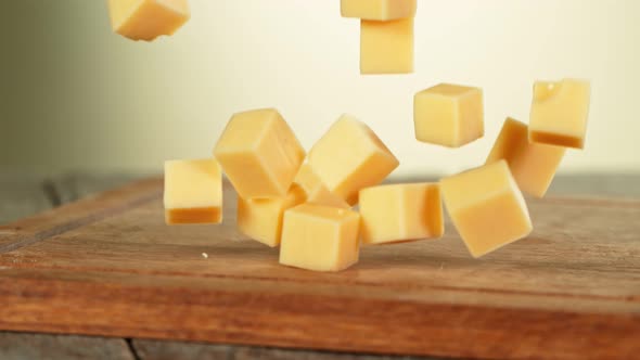 Super Slow Motion Shot of Cheese Chunks Falling on Wooden Board at 1000 Fps. alt