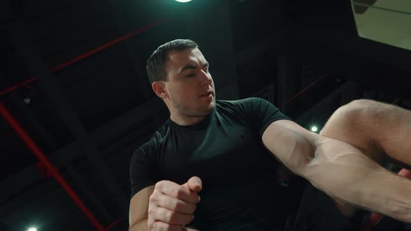 Strong Man Lifting Dumbbell and Looking at Biceps alt