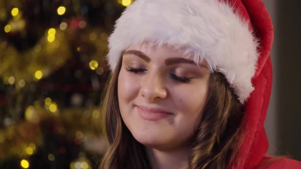 A Young Beautiful Woman Sits on a Couch in a Living Room and Daydreams - Face Closeup alt