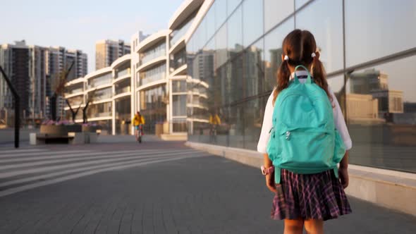 Little Pupil in School Uniform Is Going To School in City Landscape