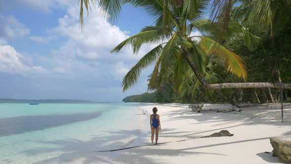 Slow motion: woman sunbathing walking on white sand beach turquoise water tropic alt