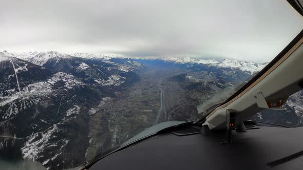 Airplane cockpit view of landing approach through Sion Valley mountains alt