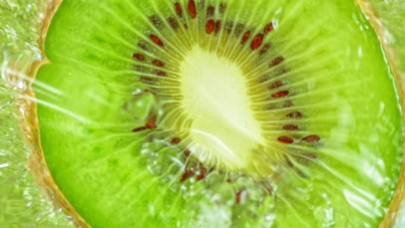 Super Slow Motion Shot of Splashing Water on Rotating Kiwi Slice at 1000Fps alt