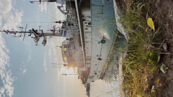 Vertical Video of the Old Fishery Vessel Standing at the Coast Through a Grass at Sunrise Sun Path alt