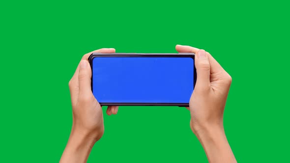 Woman hand holding the smartphone with blue screen on chroma key green screen background.