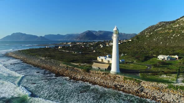 Aerial Shot Flying Toward a Lighthouse with Mountains in the Background