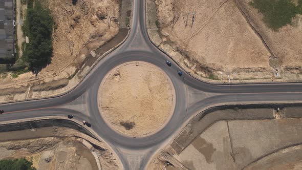Top down aerial view of a traffic roundabout. Camera departure.