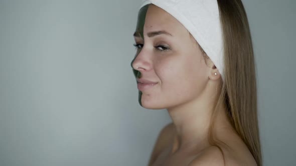 Attractive Naked Woman with Cosmetic Mask on Face Looks and Smiles Background alt