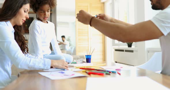 Mother and Father Drawing Together with Their Child alt