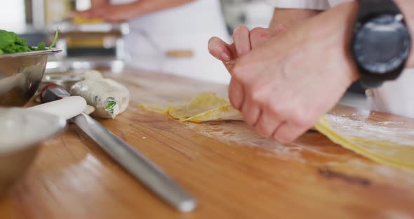 Caucasian female chef teaching diverse group preparing dishes and smiling alt