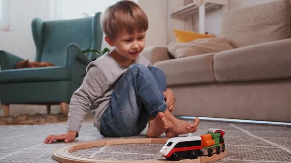 Child Play Build Wooden Railroad Starts an Electronic Steam Locomotive Sitting on the Floor at Home