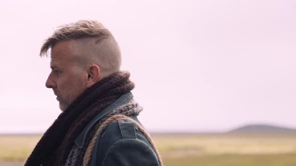 Portrait of a Stylish Blond Man with a Scarf On Gets In the Little Black House alt