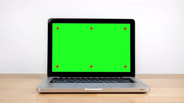 Stop motion animation green screen laptop computer on wooden desk.