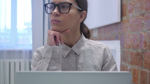 Hispanic Woman Brainstorming, Thinking for Work on Laptop alt
