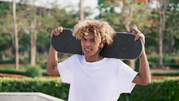 Young Man Listening To Music With Skateboard