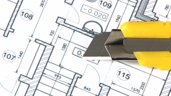 Yellow Stationery Knife on Building Plan, Rotation, Close Up alt