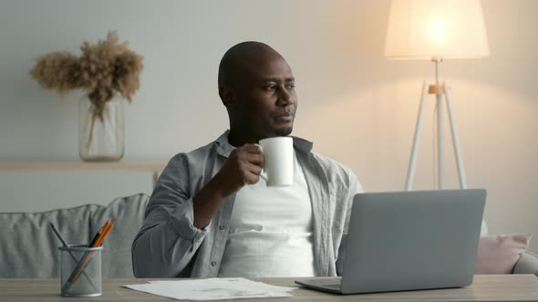 African Man At Laptop Having Coffee Working Sitting At Home alt