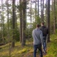 Young men hiking through a forest near a lake. - VideoHive Item for Sale