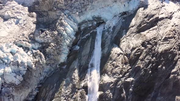 Aerial view of a waterfall with melt water from a dying glacier in Switzerland alt