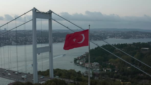 Turkish Flag Waving in Wind in Front of Istanbul Bosphorus Bridge, Aerial Medium Shot Slide Right alt