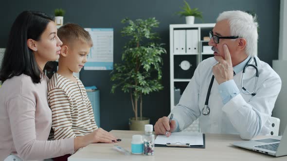 Mother and Child Talking To Doctor During Appointment in Children's Hospital alt