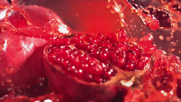 Slow Motion Shot of Pomegranate Juice Splashing Through Pomegranate alt
