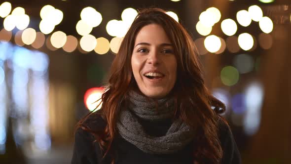 Shy Caucasian Brunette Young Female in Grey Scarf and Dark Coat Smiling Awaiting in Slowmotion alt
