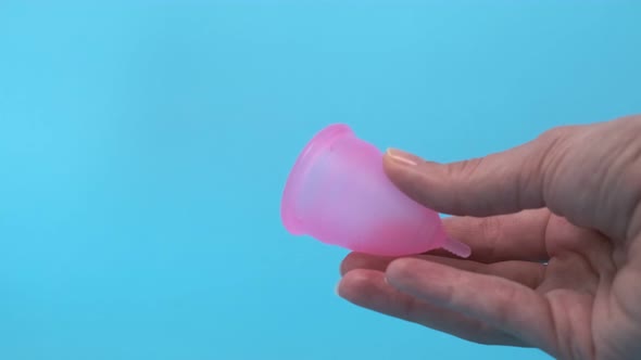 Pink Menstrual Cup Closeup on a Blue Background