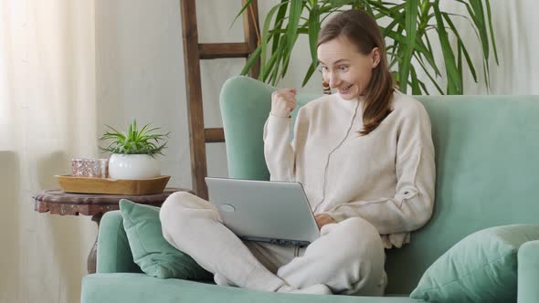 Happy Woman Excited and Glad of Success with Laptop on Chair alt