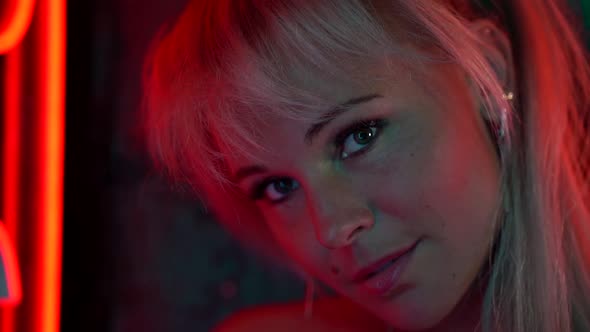 Sexy Blonde Woman in Nightclub at Night, Closeup Portrait, Looking at Camer and Smiling, Flirting alt