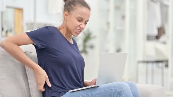 Tired African Woman with Laptop Having Back Pain at Home  alt