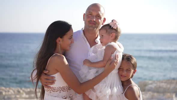 Proud Happy Caucasian Father Standing with Daughters on Mediterranean Sea Coast Looking at Camera alt