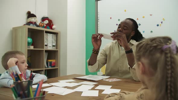 African American Teacher and Pupils Study the Figures in the Classroom During the Lesson alt